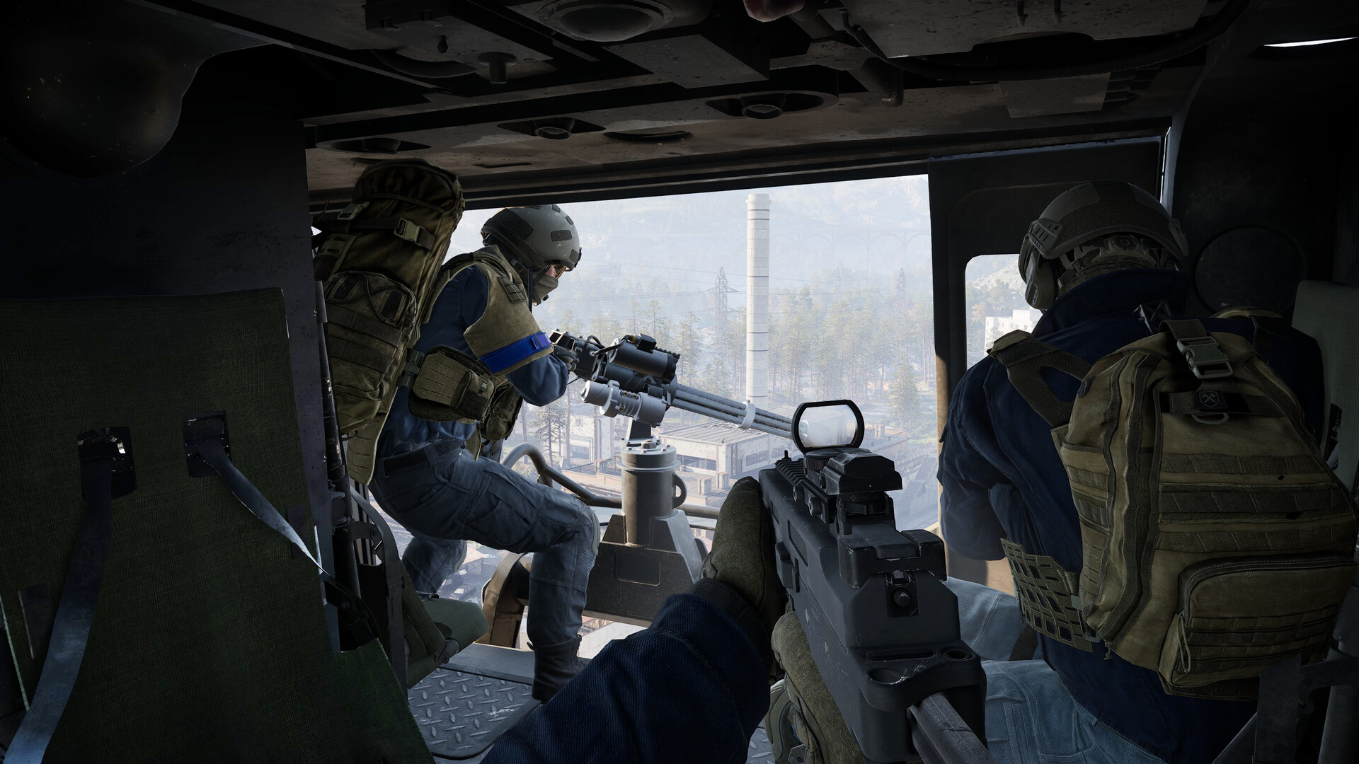 WARDOGS — Three soldiers inside a combat vehicle; one fires a mounted machine gun while others hold rifles, overlooking an industrial area from within the vehicle.